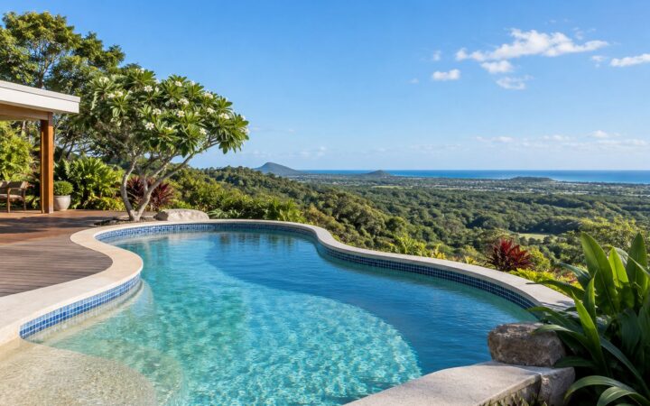 Freeform concrete pool with blue waterline tiles overlooking Sunshine Coast hinterland and ocean views